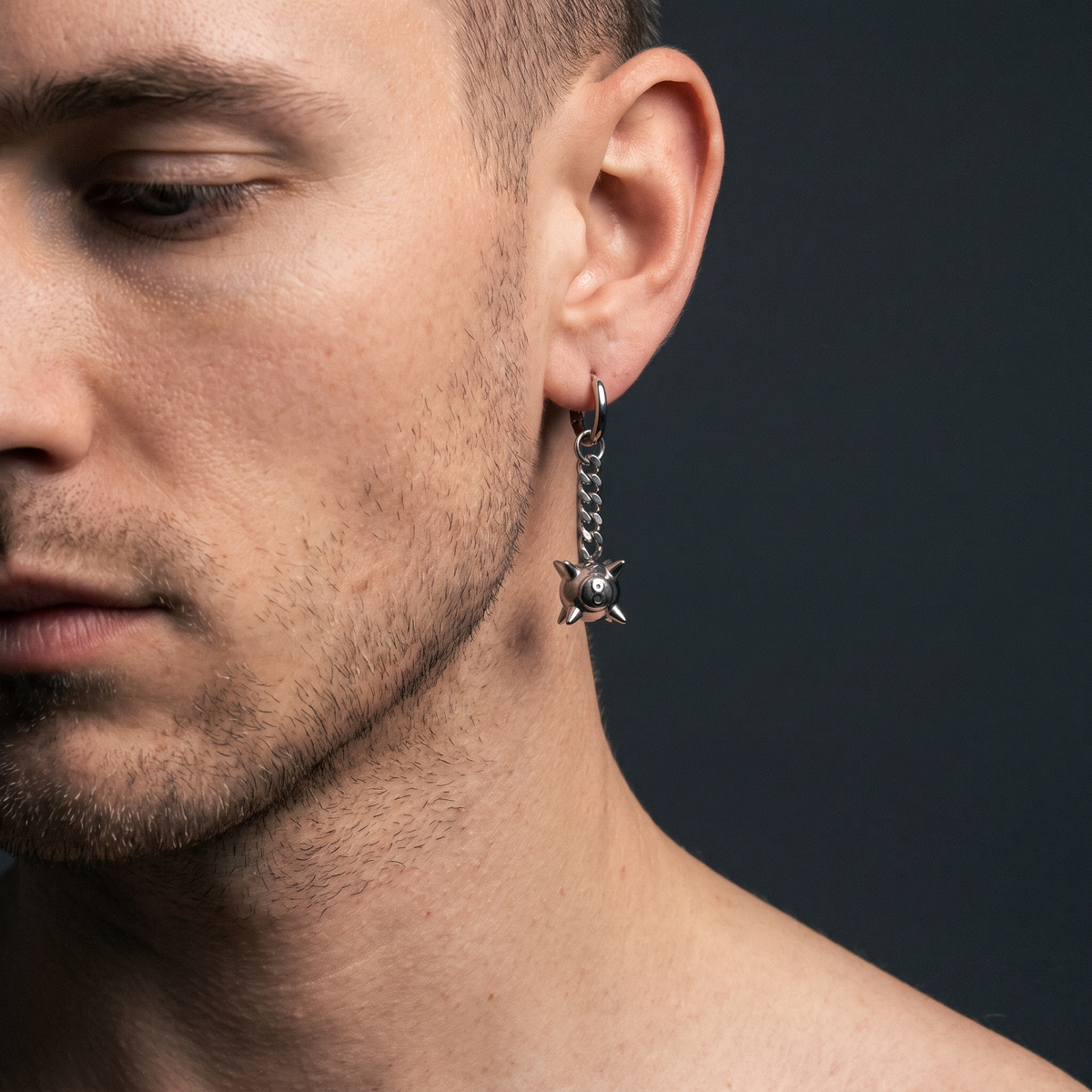 Spiked 8-ball earrings worn on model — clean-cut male